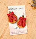Red and pink striped bow earrings hanging from gold-tone hoops, displayed on a Coco & May jewellery card