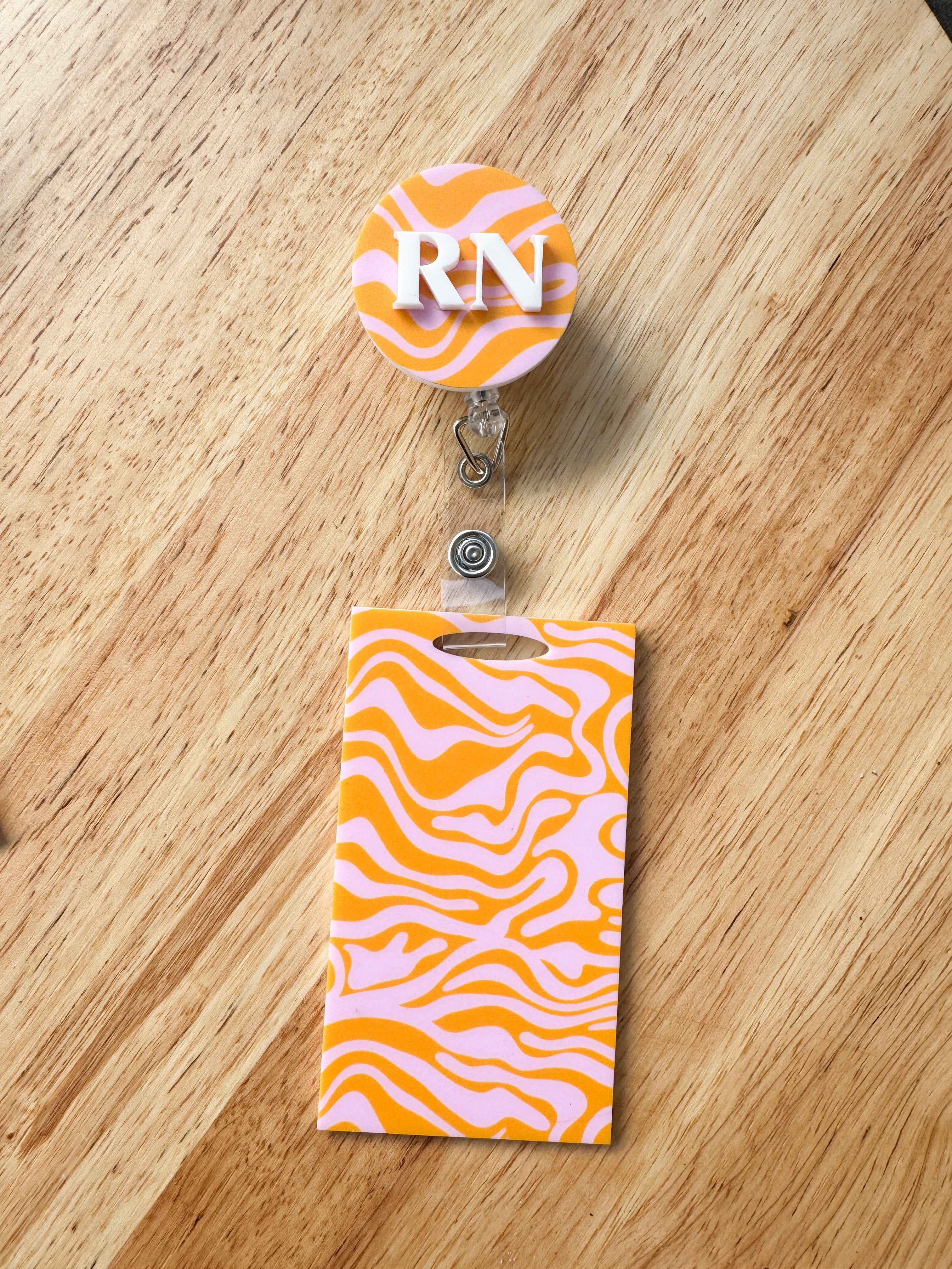 Patterned acrylic badge reel with retractable ID holder, designed for nurses, teachers and everyday workwear.
